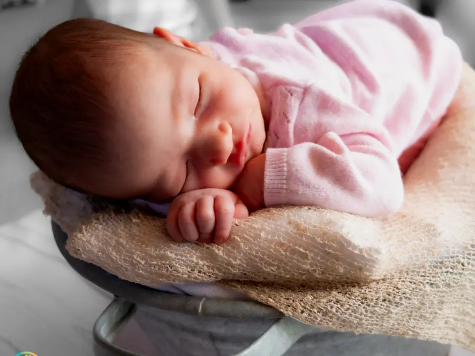 Schlafendes Neugeborenes in rosa Kleidung auf einer Decke